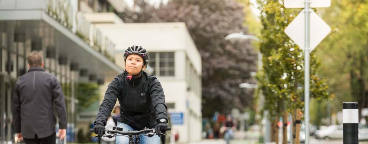 A woman rides her bike on a cycle path.