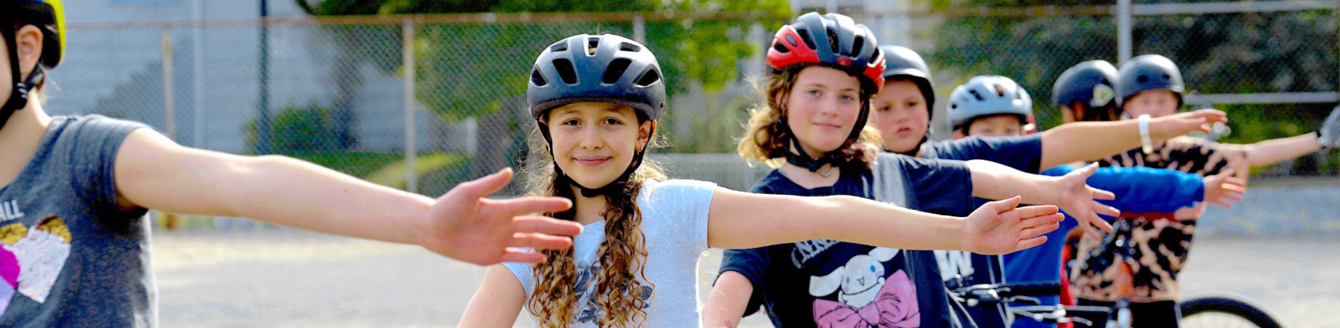 Eight students indicate a left turn single by stretching out their left arm. They are all wearing helmets.