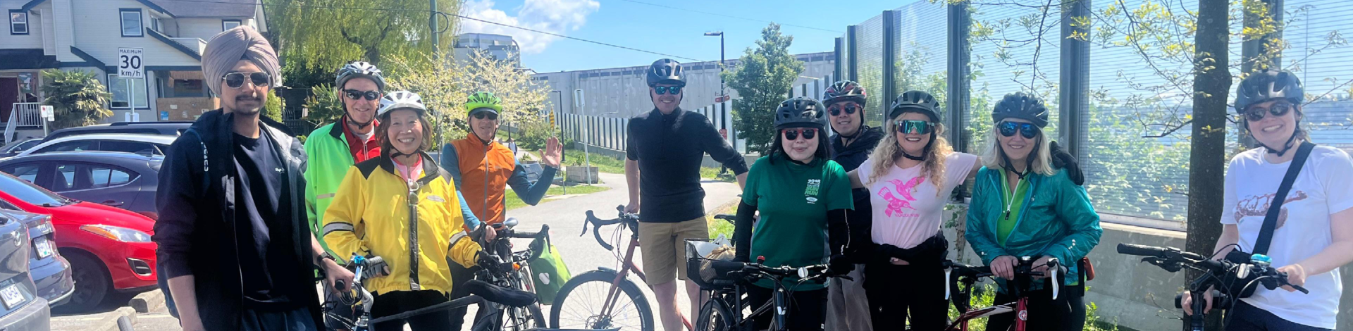 Ten people pose for a photo with their bikes on a cycling path in North Vancouver.