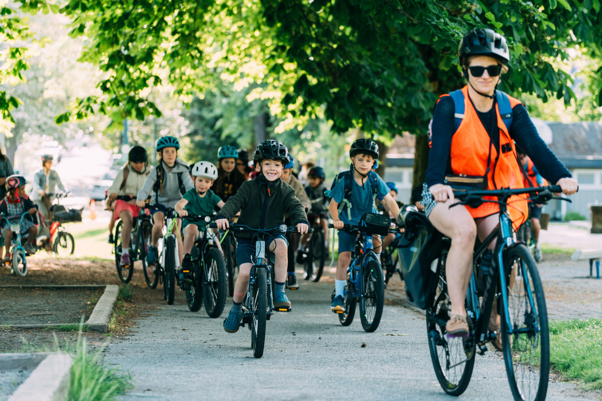 An instructor leads a group of students on a bike ride.