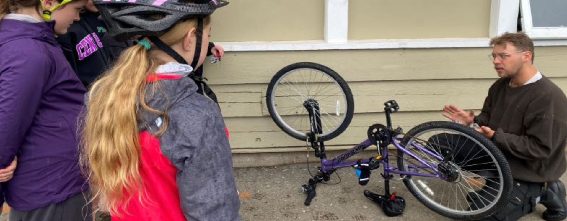 An instructor teaches bike mechanics to students.