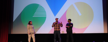 Three people stand on stage at the Rio Theatre at the Bicycle Film Festival.