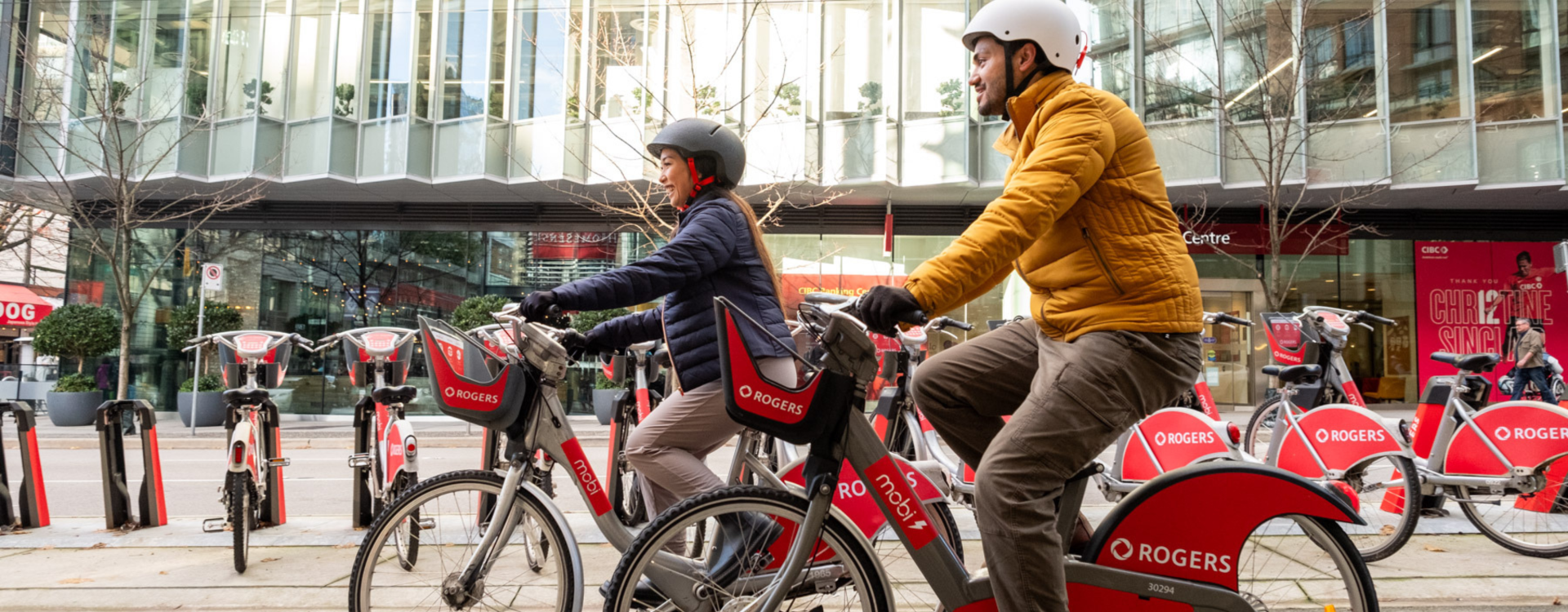 A man and a woman ride Mobi by Rogers bikes.