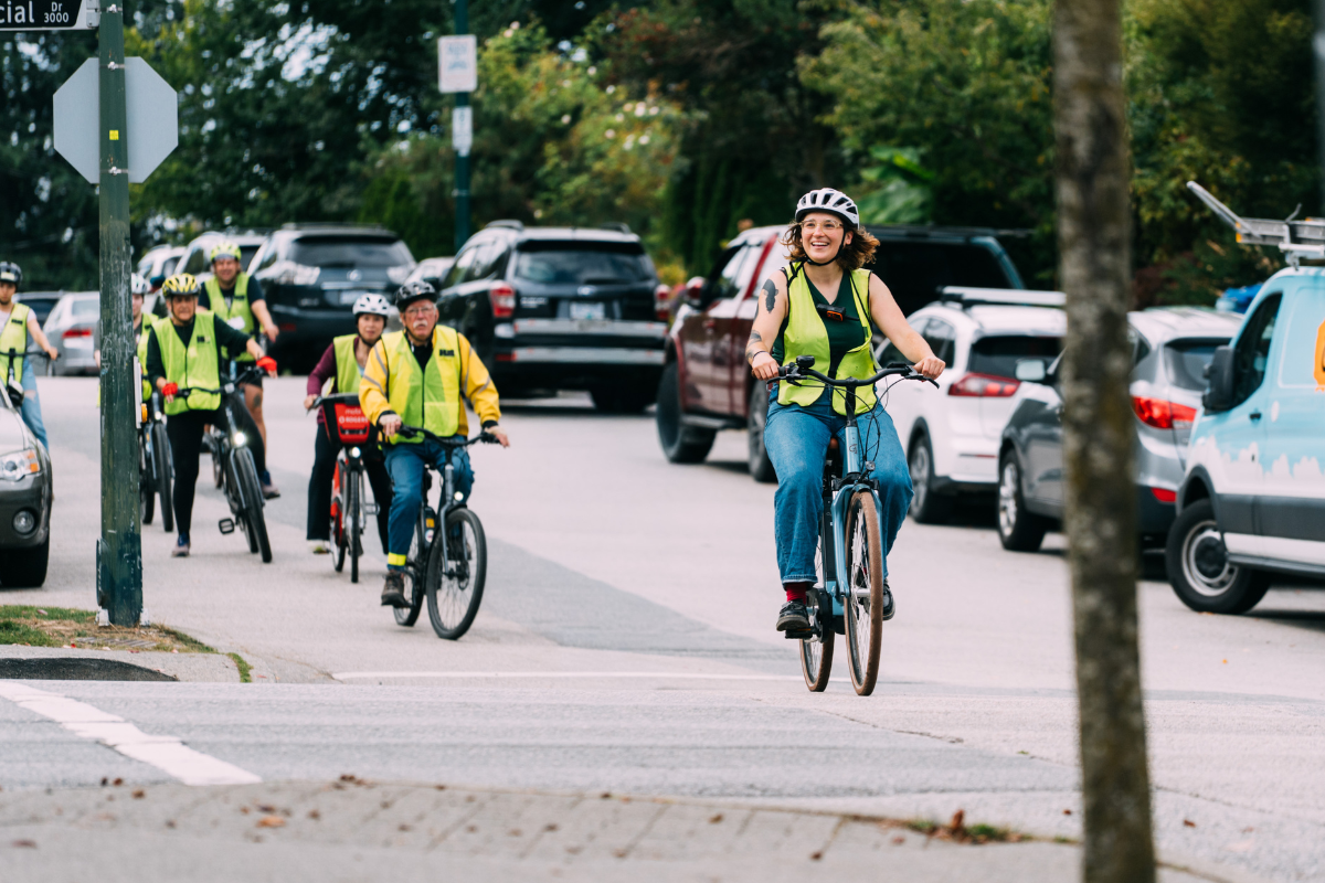 A bike education instructor leads a group of adults on a group road ride.