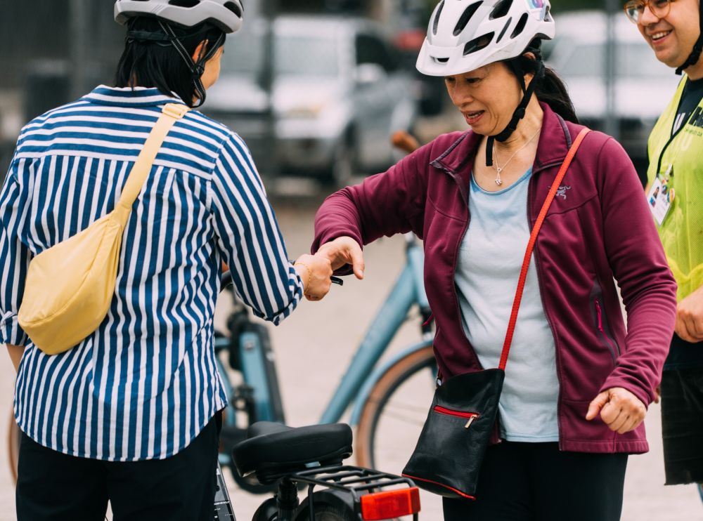 Several people gather around a bike.