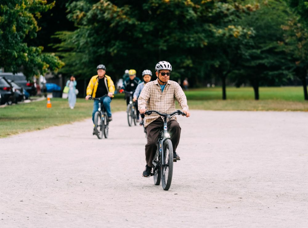 A man rides a bike on a gravel field.