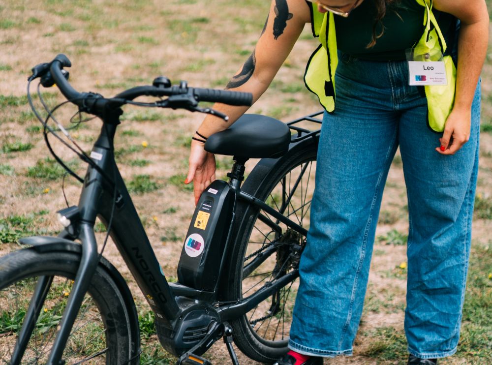 An instructor bends down to inspect a bike.