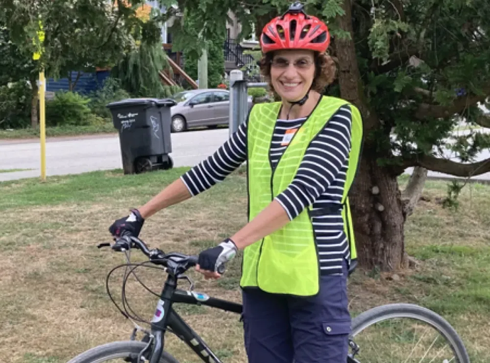 Roberta Walker, a senior woman stands with a bike.