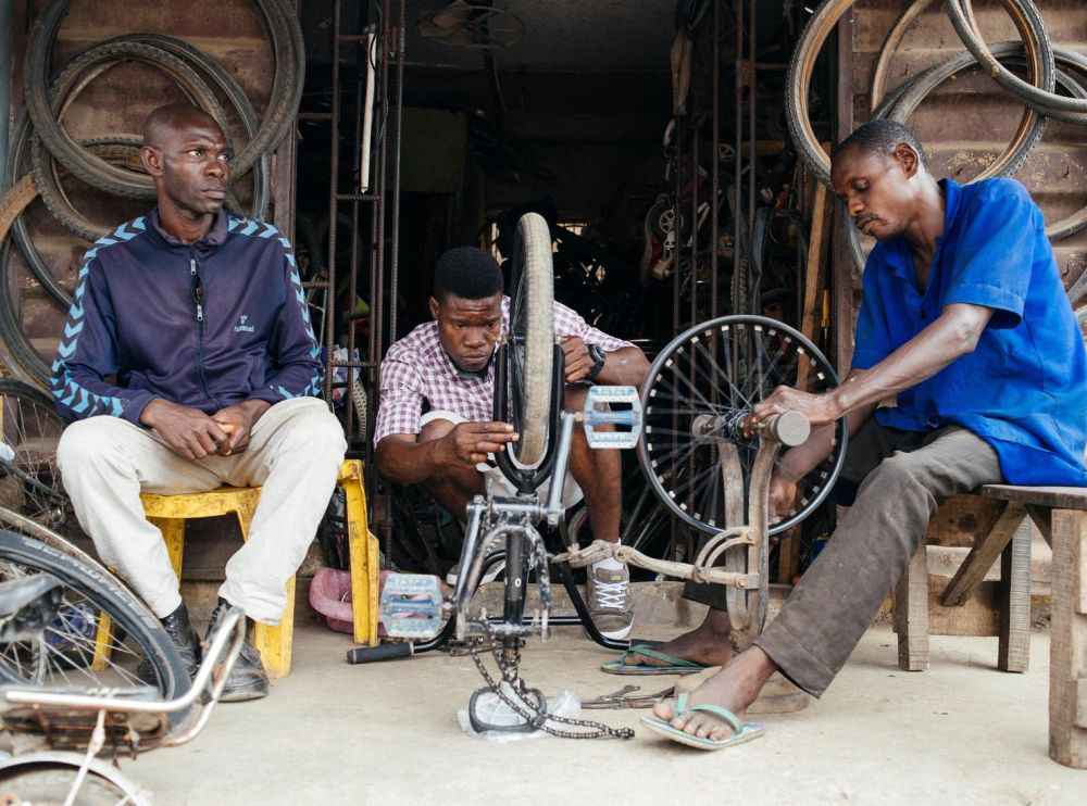 Three men repair bikes.
