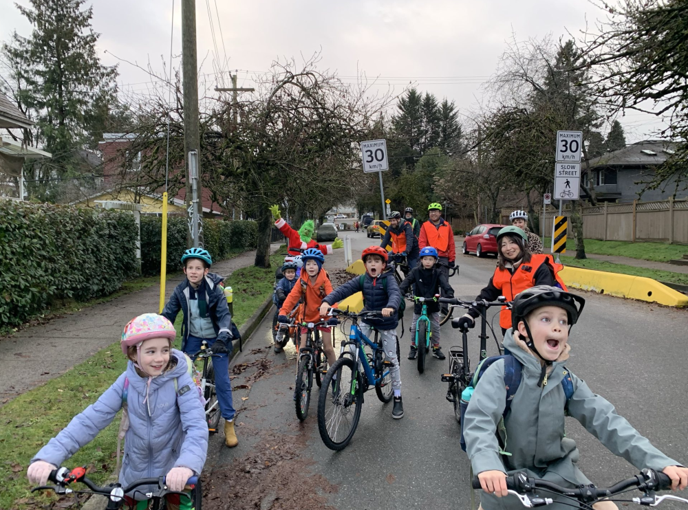 A group of students ride their bikes to school in an organized bike bus.