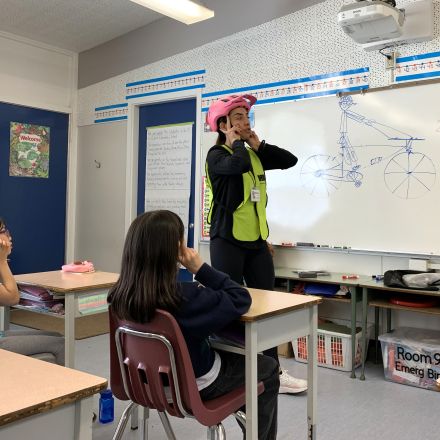 Instructor demonstrating helmet fit in a classroom