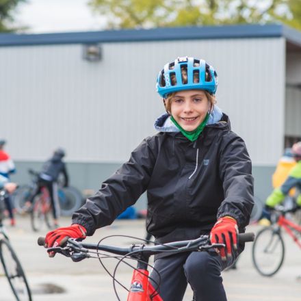 A boy rides his bike on school grounds.
