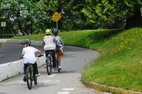 Three young boys ride bikes in Stanley Park.