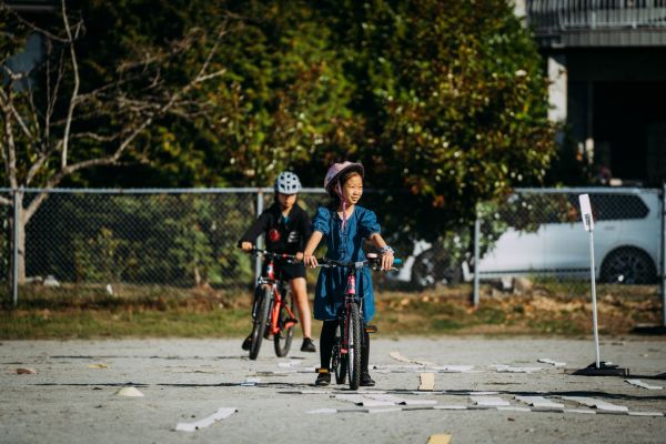 A young girl rides her bike on school grounds.