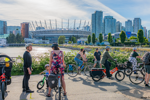 People on bikes on the Vancouver Seawall by BC Place. Image Credit: Alex Trujillo 