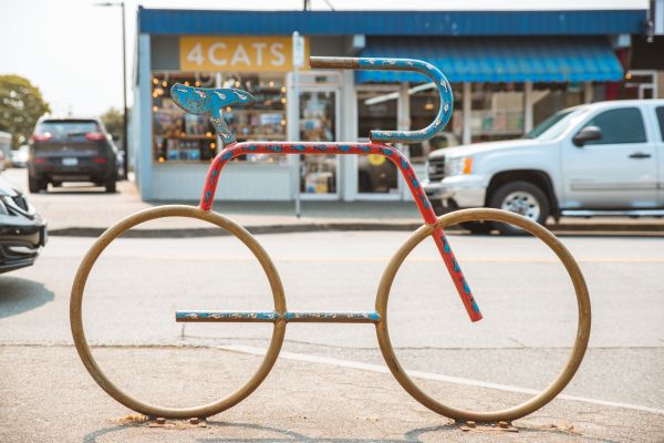 A bike-shaped bike rack outside a storefront.