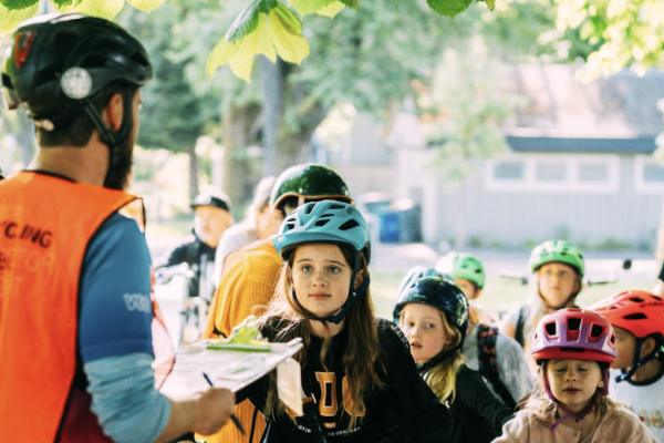 A bike education instructors speaks to a group of students.