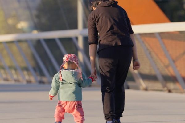 A parent holds the hand of their toddler as they walk over the new Burnaby Lake Overpass.