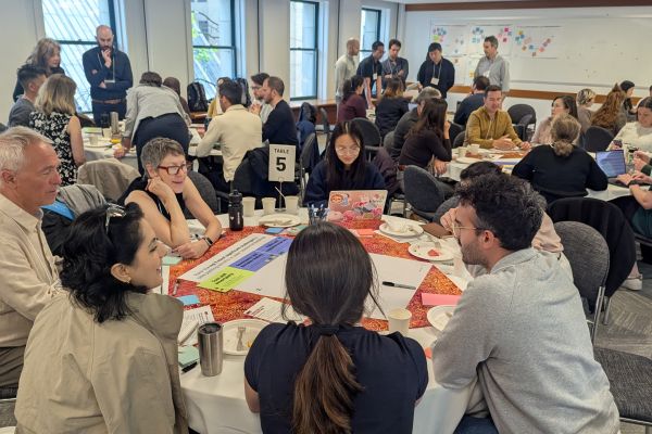 A group of people gather around a table at a bike parking retrofits workshop.