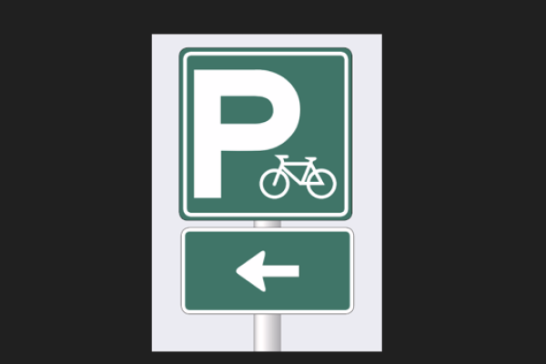 A bike parking sign with an arrow pointing left.
