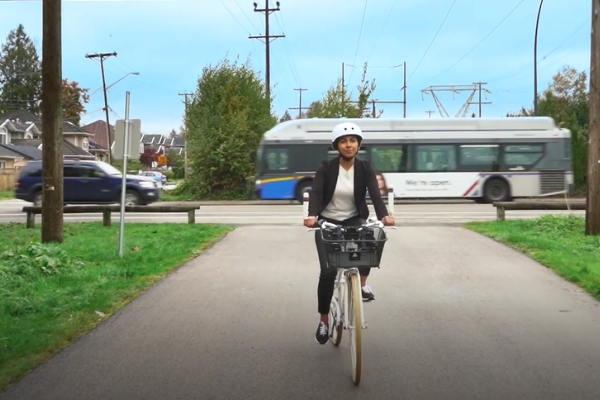 woman riding bike on a quiet path with bus behind her