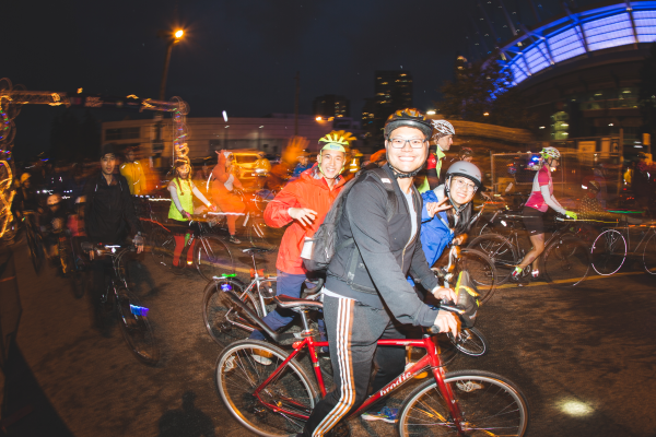 A group of people ride their bikes at HUB Cycling's Bike the Night event. This photo was taken by @braydenrastadphoto.