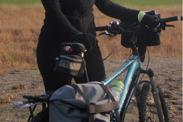 A photo of Colleen MacDonald with her bike and panniers.