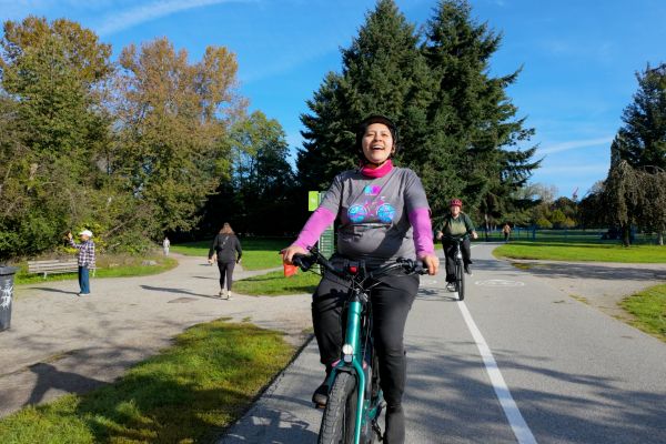 A woman rides her bike on a separated cycling path. The photo credit is Tim Chung.