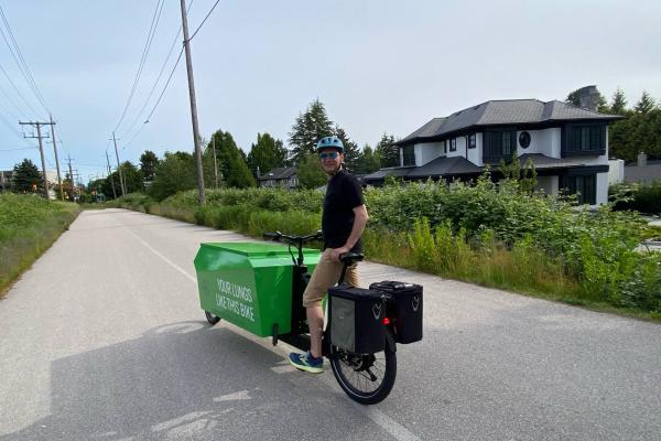 A photo of Chris' e-cargo bike. The bike is green and has "COOLER THAN A TRUCK" written on the side.