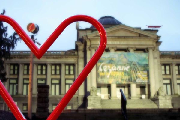 Vancouver Art gallery can be seen behind a heart shaped bike rack
