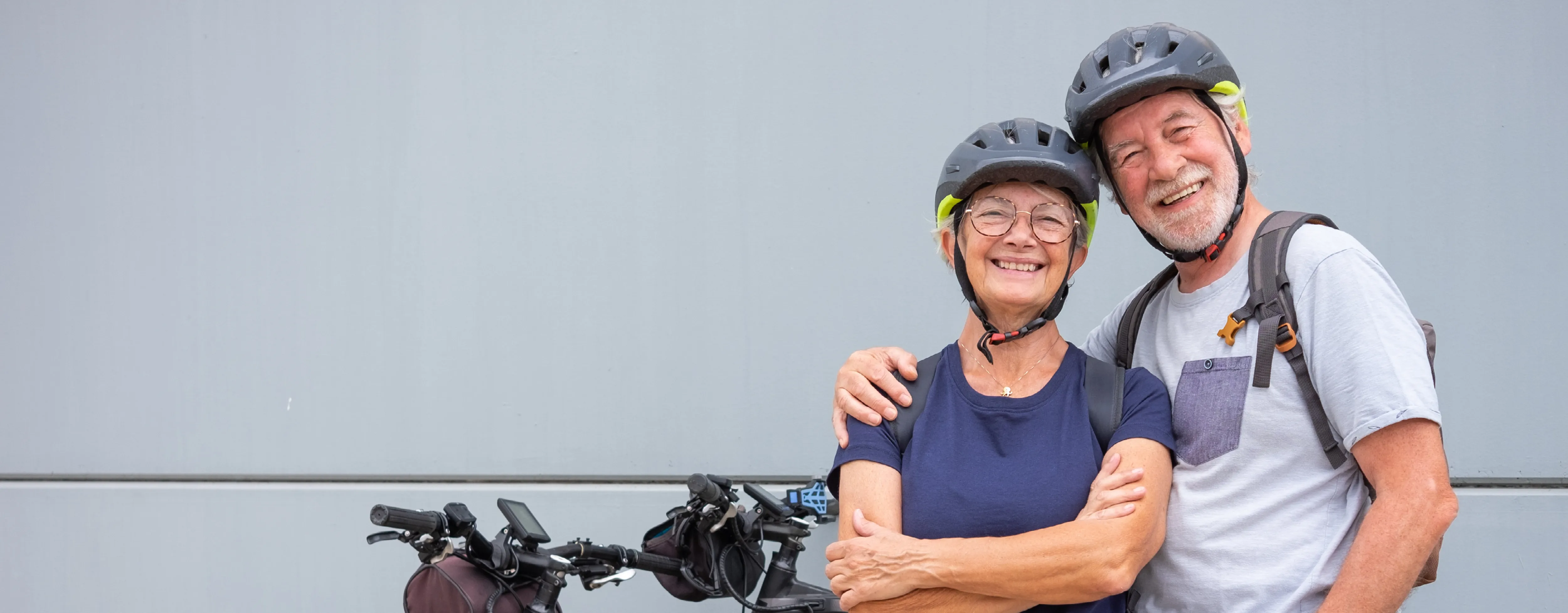 A senior couple poses with their e-bikes.