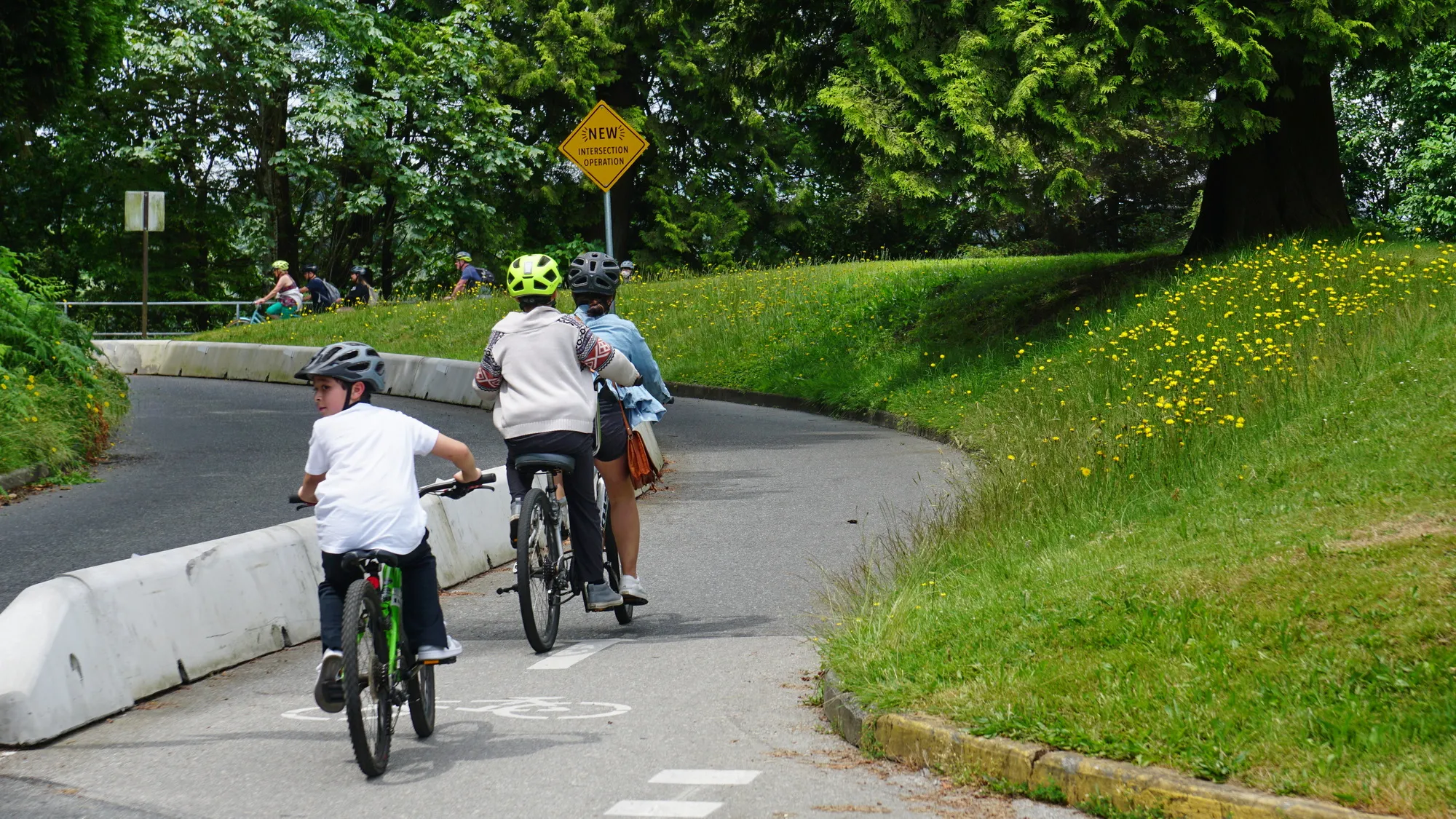Three young boys ride bikes in Stanley Park.