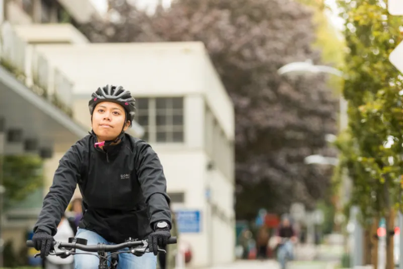 A woman rides a bike on a shared path.