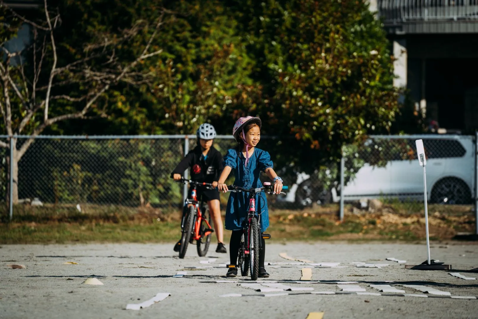 A young girl rides her bike on school grounds.