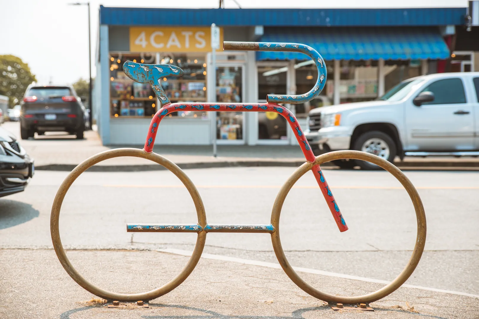 A bike-shaped bike rack outside a storefront.
