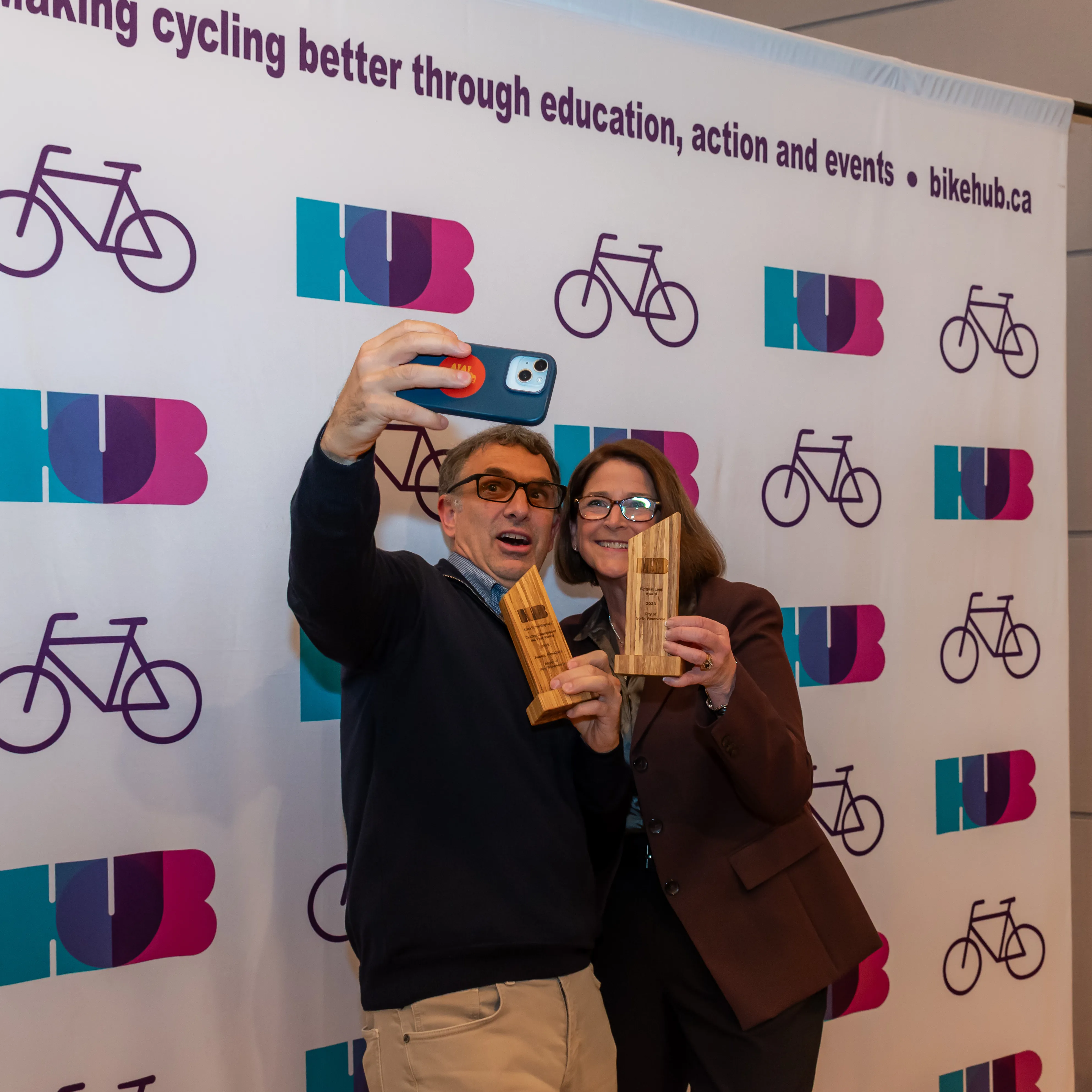 Two people take a selfie with their HUB Bike Awards.