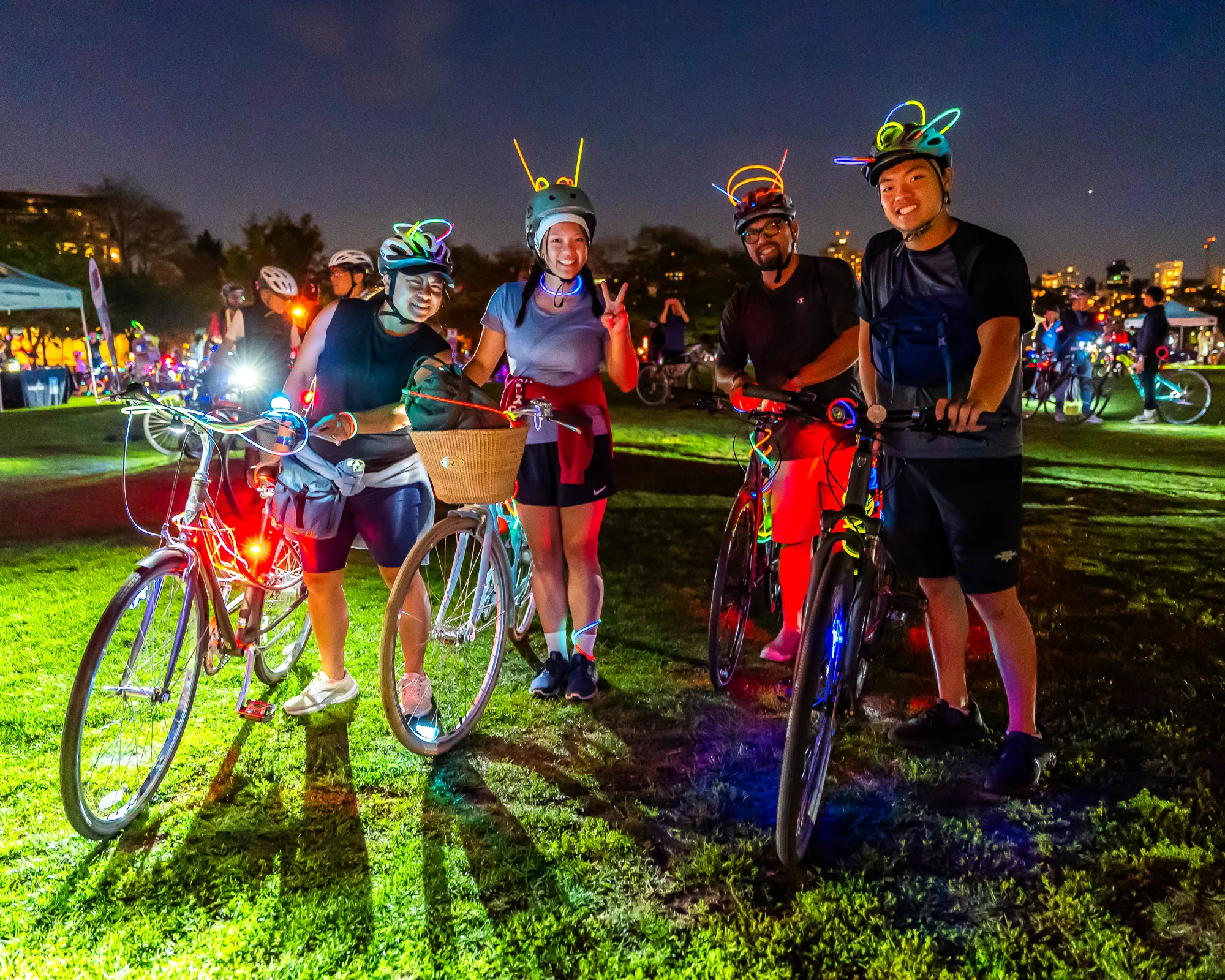 Four friends pose with their bikes in a grass field at Bike the Night.