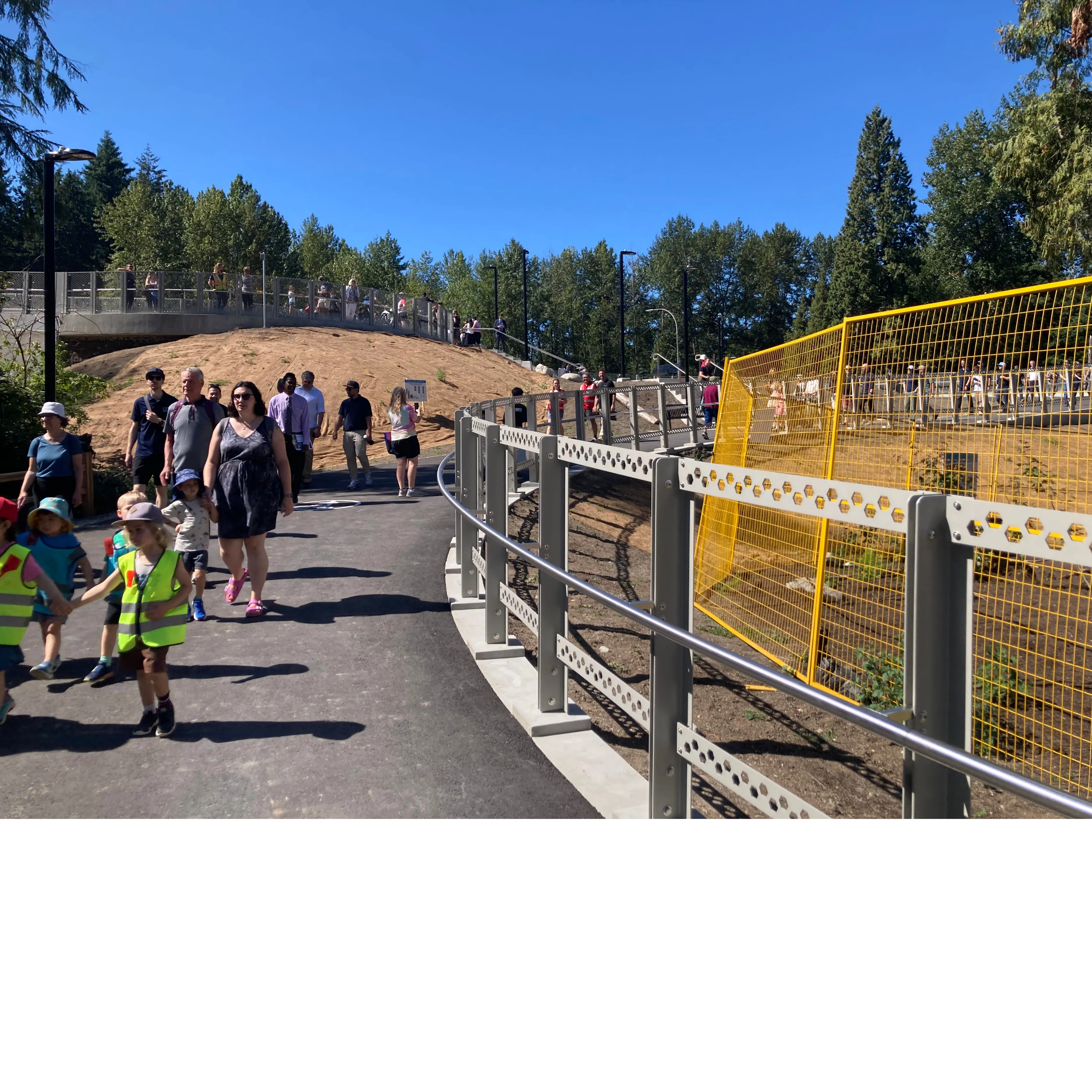 a large group of kids and adults walk over the new Crosscut Bridge overpass